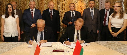 Prezesi PAN i NASB podpisują umowę w otoczeniu współpracowników