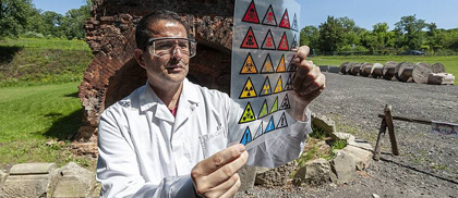 Naukowiec na poligonie ogląda grafikę z symbolami toksycznych substancji