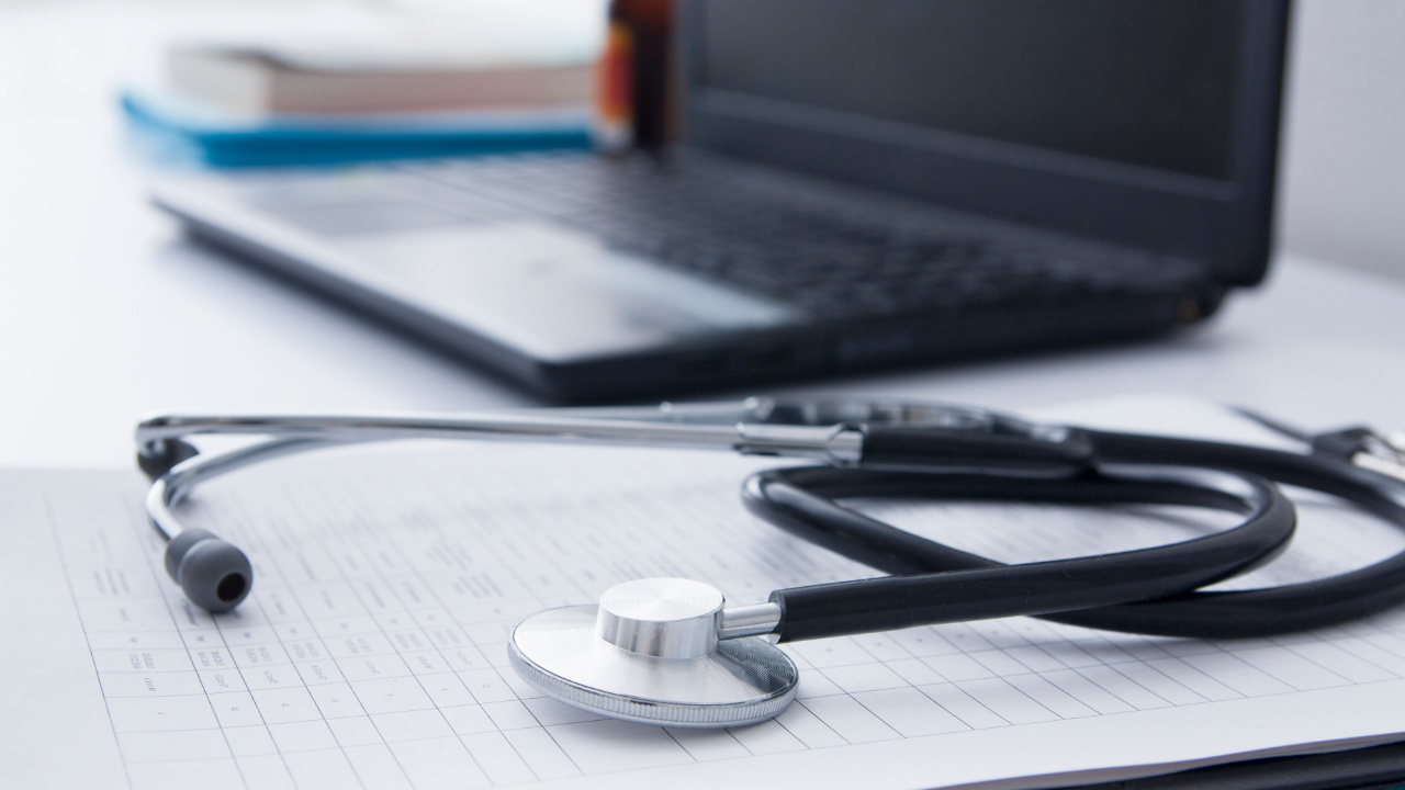 Stetoskop, laptop i dokumenty na biurku