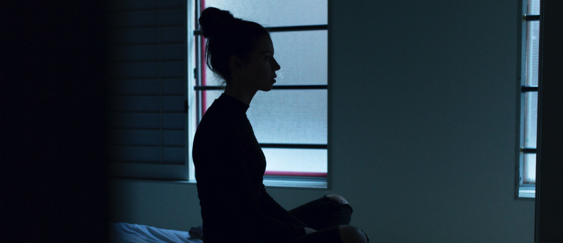 Kobieta siedząca w ciemnym pokoju
