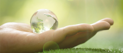 Zielona planeta w dłoniach symbolizująca ochronę klimatu